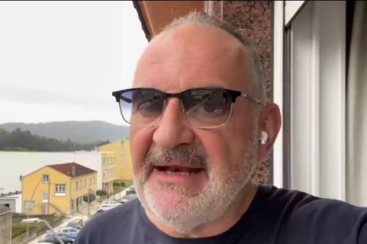 Antón Losada, con gafas oscuras y auriculares, de pie en un balcón con edificios y montañas al fondo Antón Losada, con gafas oscuras y auriculares, de pie en un balcón con edificios y montañas al fondo