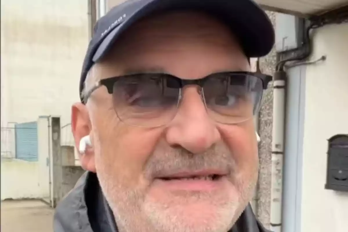 Antón Losada, con gafas, gorra azul y auriculares blancos caminando al aire libre Antón Losada, con gafas, gorra azul y auriculares blancos caminando al aire libre
