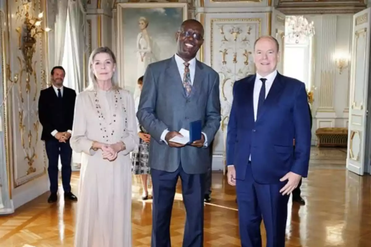 Carolina de Mònaco i el príncep Albert posen en una majestuosa sala del palau monegasc amb un dels guanyadors dels Premis Príncep Pierre, que apareix al centre de la imatge. Carolina de Mònaco i el príncep Albert posen en una majestuosa sala del palau monegasc amb un dels guanyadors dels Premis Príncep Pierre, que apareix al centre de la imatge.