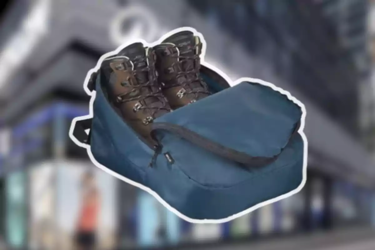 Un parell de botes de senderisme dins d’una bossa blava amb tancament sobre un fons desenfocat d’una ciutat