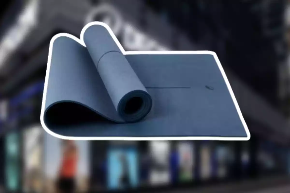 Esterilla de ioga blava desenrotllada amb fons de botiga desenfocat