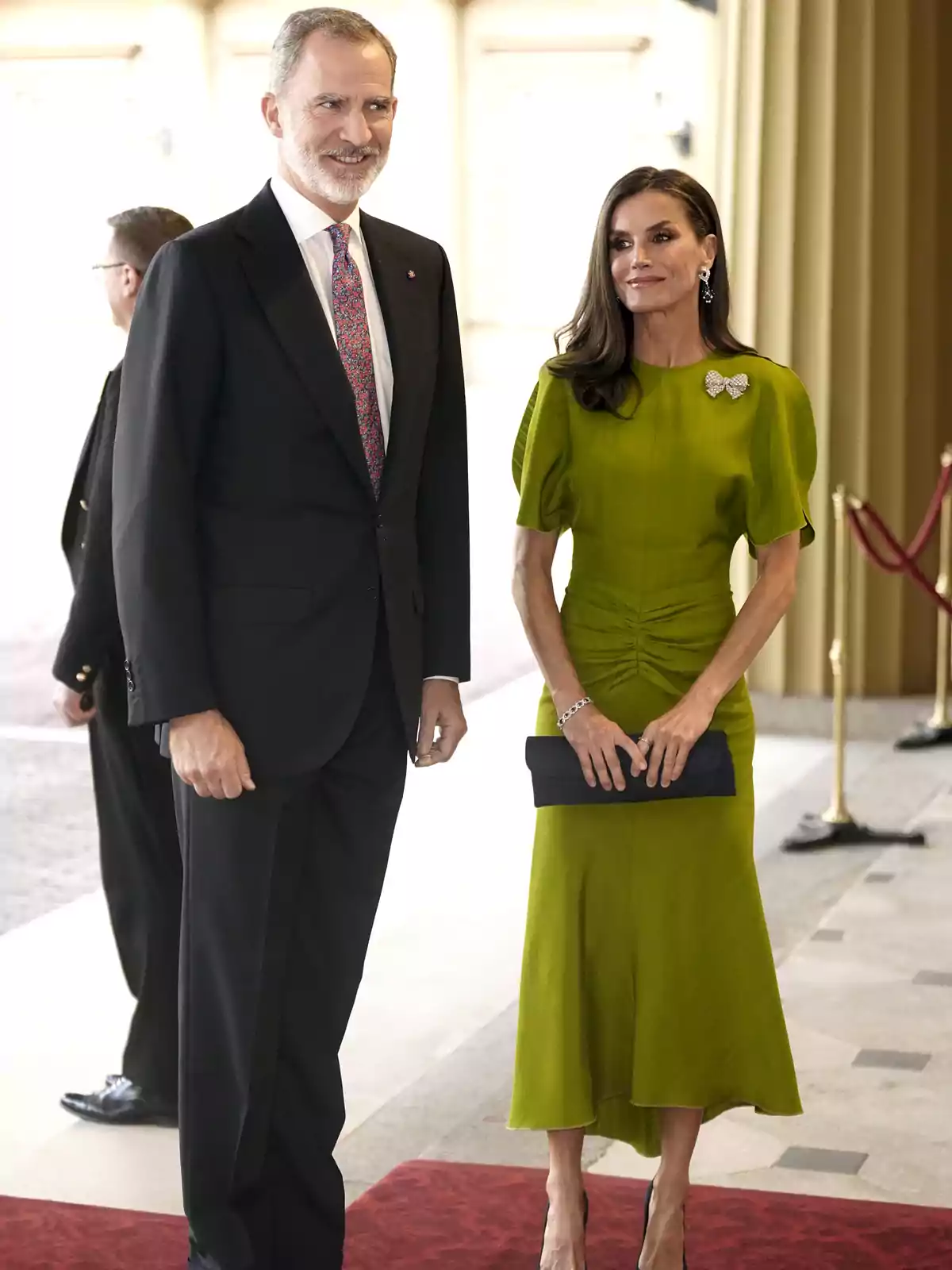 Felip VI amb vestit fosc i corbata colorida està dret al costat de la reina Letícia amb vestit verd i bossa negra, tots dos posant sobre una catifa vermella en un entorn elegant. Felip VI amb vestit fosc i corbata colorida està dret al costat de la reina Letícia amb vestit verd i bossa negra, tots dos posant sobre una catifa vermella en un entorn elegant.