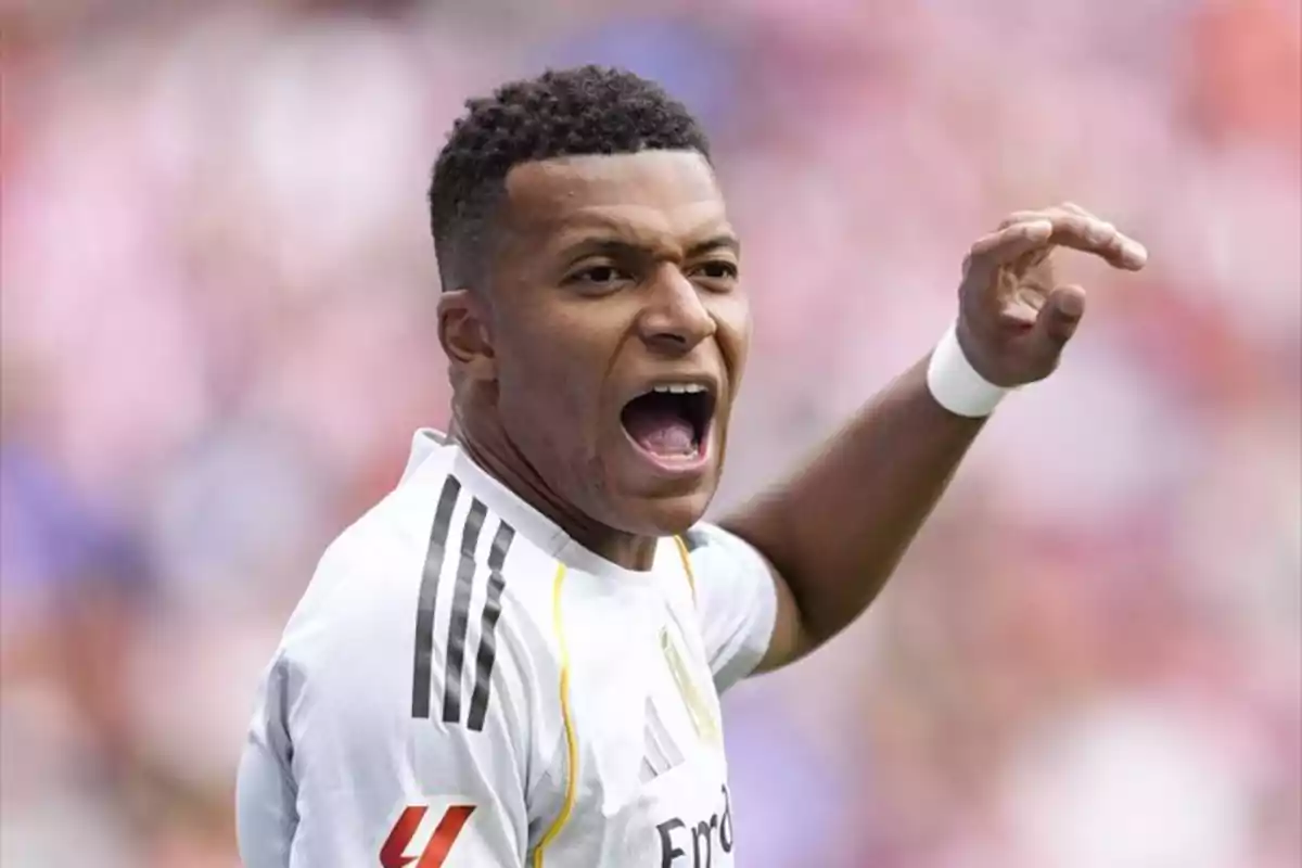 Futbolista amb uniforme blanc celebrant efusivament en un estadi Futbolista amb uniforme blanc celebrant efusivament en un estadi