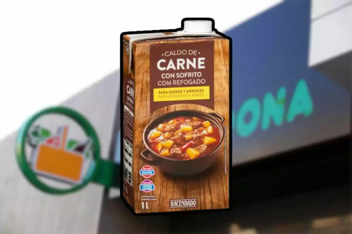 Envàs de brou de carn amb sofregit de la marca Hacendado davant d’un cartell borros de supermercat