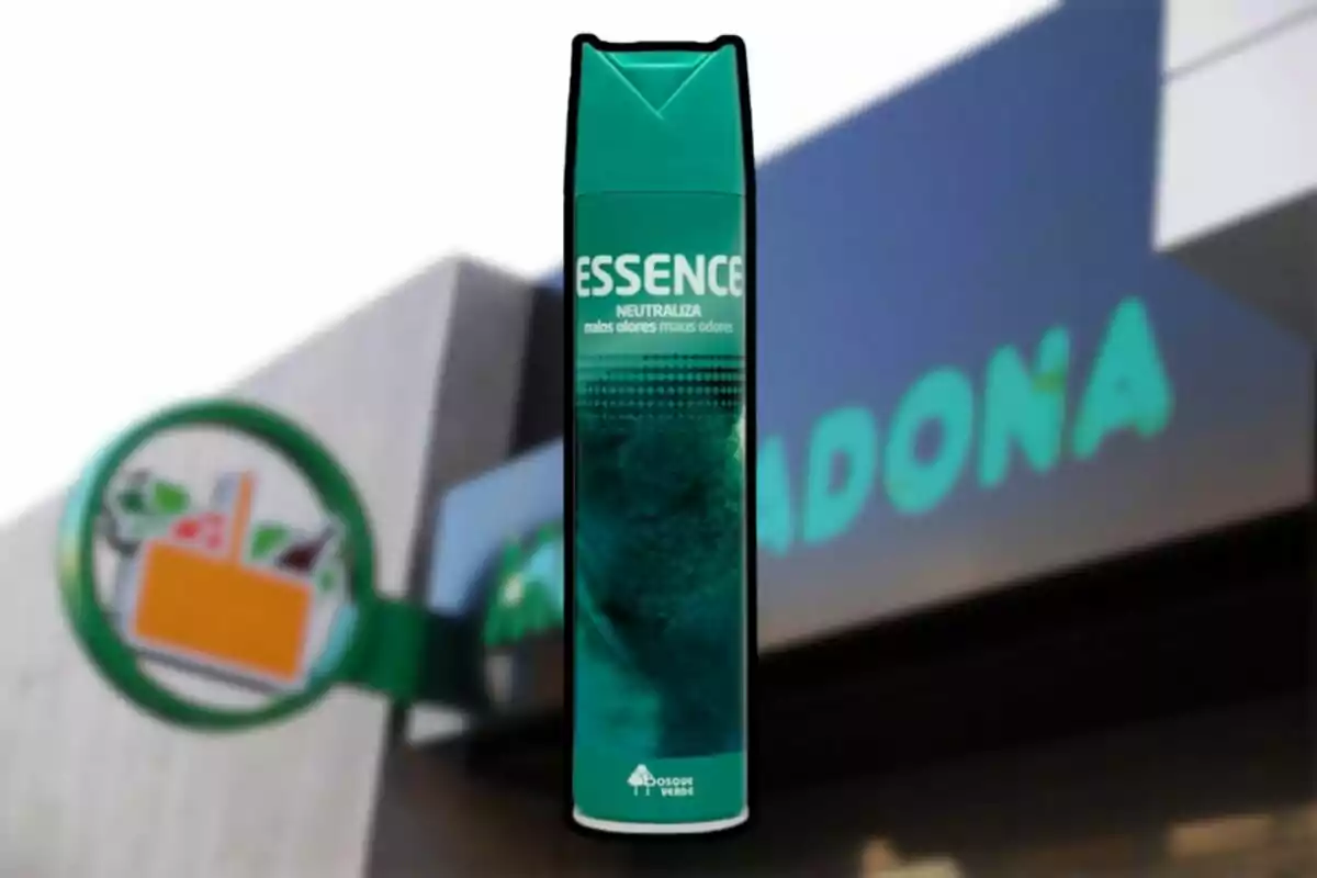 Ambientador en aerosol de la marca Essence frente a una tienda de supermercado desenfocada
