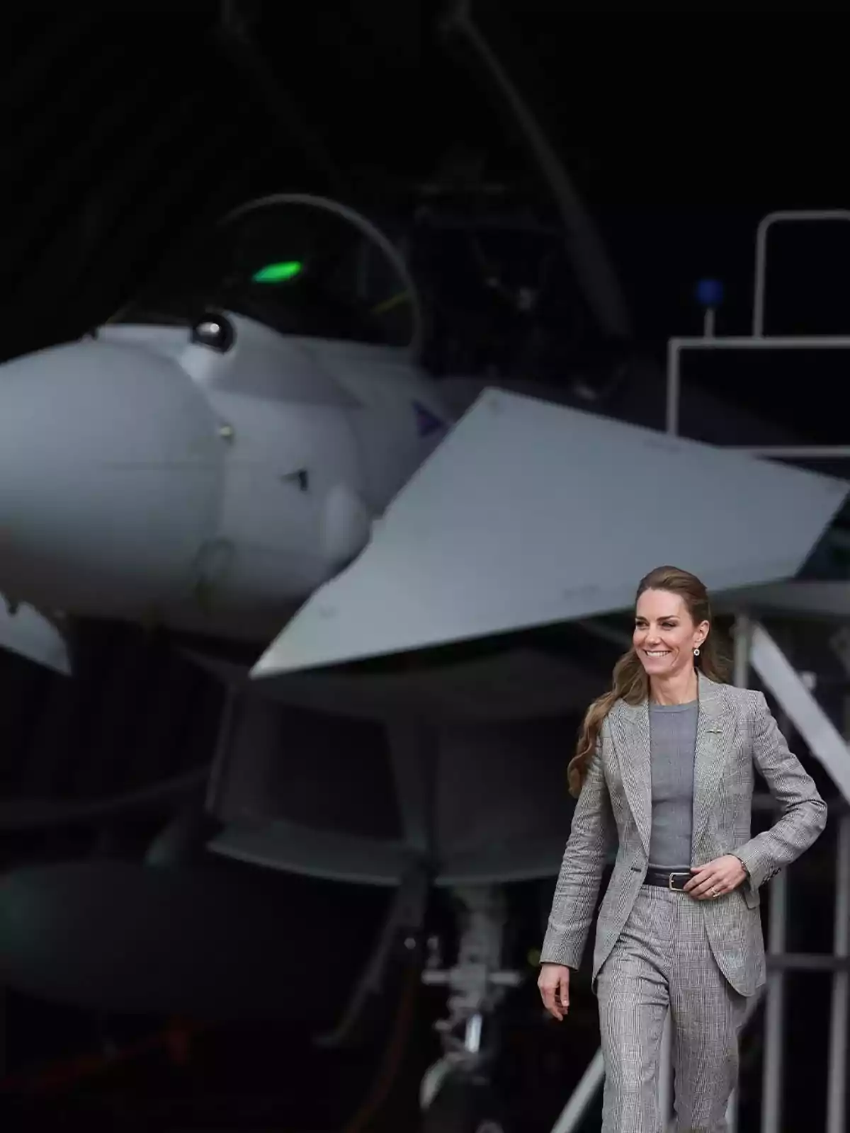 Kate Middleton amb vestit gris caminant davant d’un avió de combat Kate Middleton amb vestit gris caminant davant d’un avió de combat