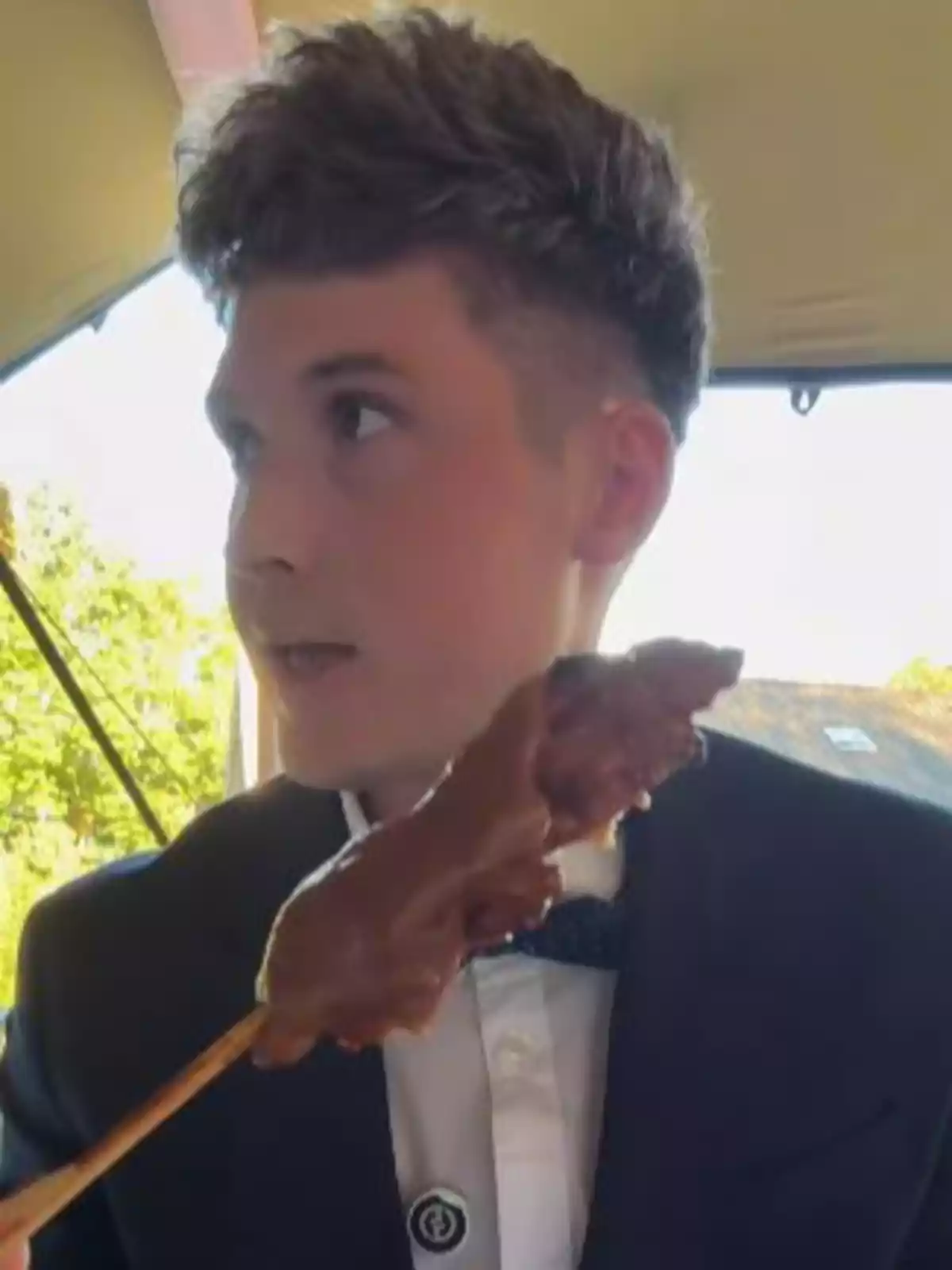 Jove amb esmòquing sostenint una broqueta coberta de xocolata Jove amb esmòquing sostenint una broqueta coberta de xocolata