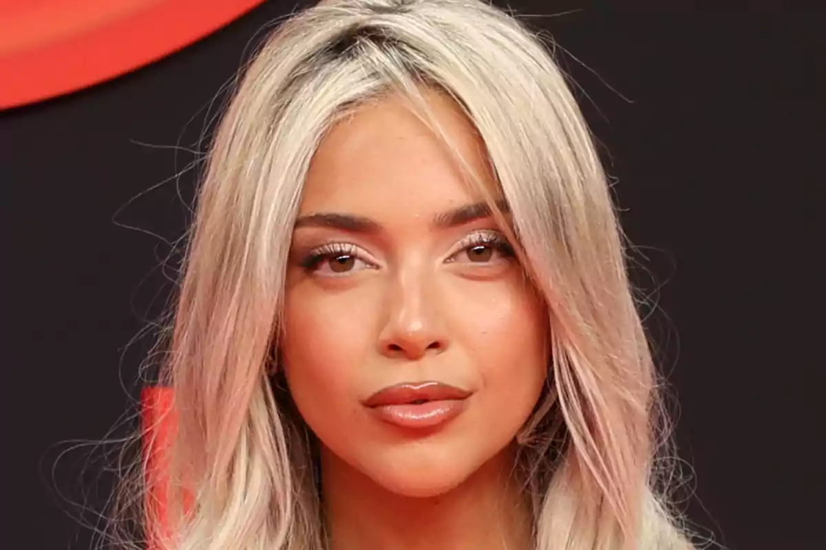 Ana Mena amb els llavis maquillats mirant a la càmera amb un fons fosc Ana Mena amb els llavis maquillats mirant a la càmera amb un fons fosc