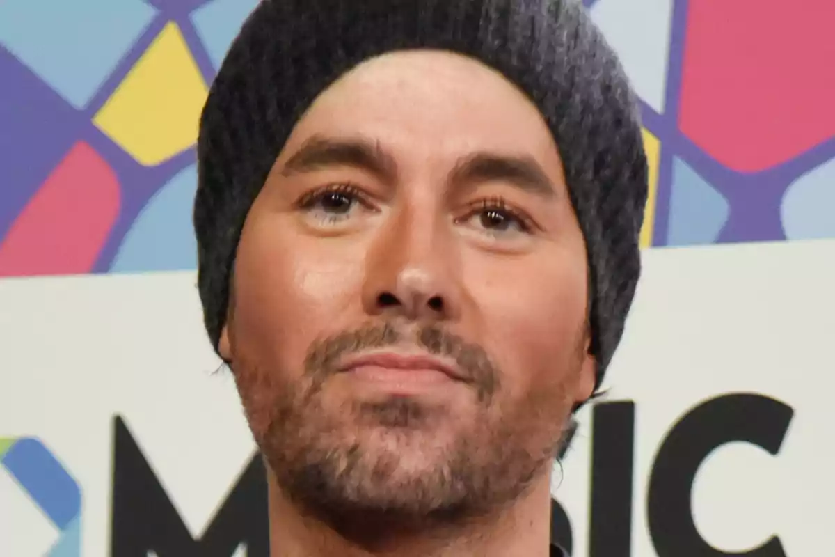 Enrique Iglesias amb gorra grisa posant davant d’un fons colorit geomètric Enrique Iglesias amb gorra grisa posant davant d’un fons colorit geomètric