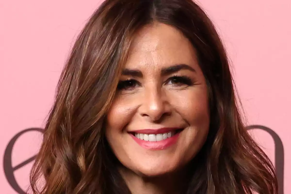 Nuria Roca sonriendo frente a un fondo rosa Nuria Roca sonriendo frente a un fondo rosa