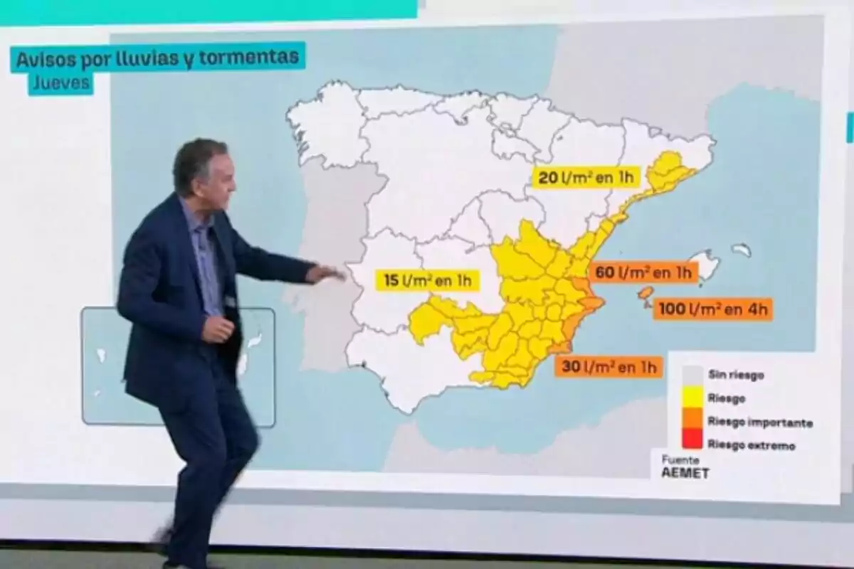 Roberto Brasero assenyalant un mapa d’Espanya amb alertes per pluges i tempestes a diferents regions, utilitzant colors groc i taronja per indicar nivells de risc i quantitats de precipitació esperades.
