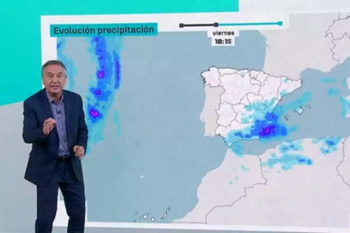 Roberto Brasero explicant la previsió de precipitacions davant d’un mapa d’Espanya i Portugal amb àrees de pluja ressaltades en blau i morat.