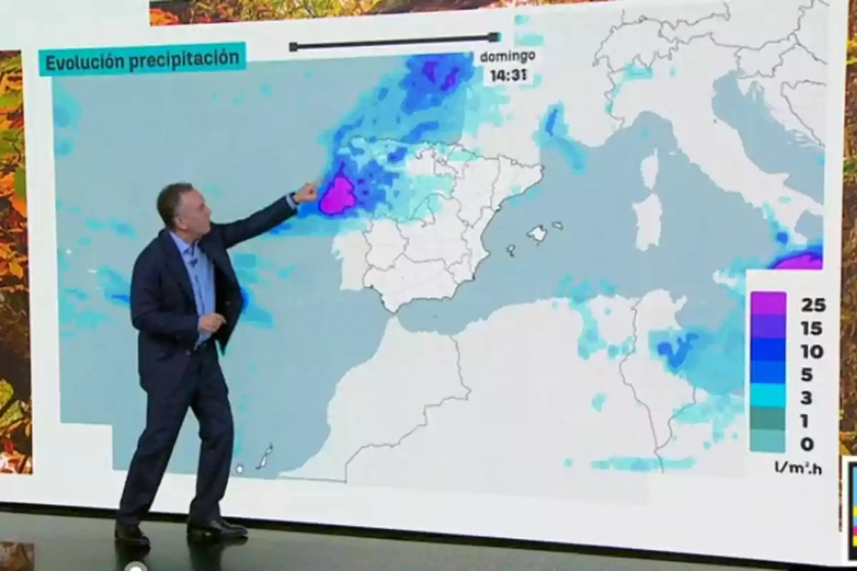 Roberto Brasero assenyalant un mapa meteorològic d’Espanya amb zones de precipitacions marcades en diferents colors.
