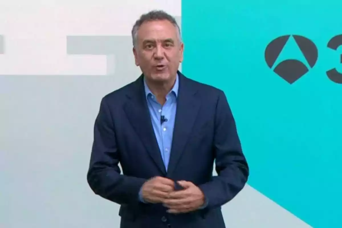 Roberto Brasero parlant davant d’una pantalla amb fons blau i un logotip geomètric.