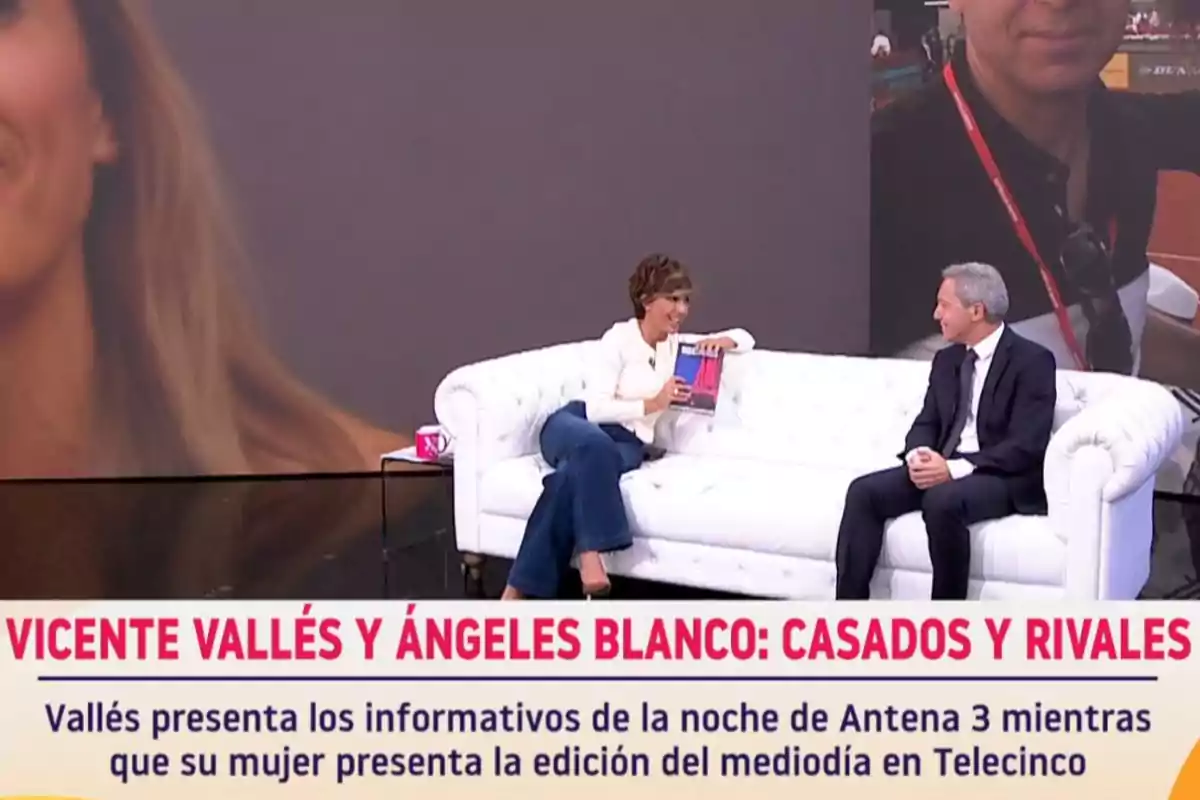 Sonsoles Ónega i Vicente Vallés conversen asseguts en un sofà blanc en un plató, amb un gran fons de pantalla i un text a la part inferior que esmenta Vicente Vallés i Ángeles Blanco com a casats i rivals en diferents cadenes de notícies. Captura de 'Y ahora Sonsoles' Sonsoles Ónega i Vicente Vallés conversen asseguts en un sofà blanc en un plató, amb un gran fons de pantalla i un text a la part inferior que esmenta Vicente Vallés i Ángeles Blanco com a casats i rivals en diferents cadenes de notícies. Captura de 'Y ahora Sonsoles'
