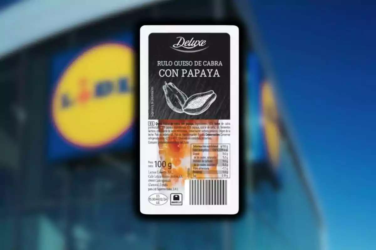 Envase de rulo de queso de cabra con papaya de la marca Deluxe frente a una tienda Lidl desenfocada.
