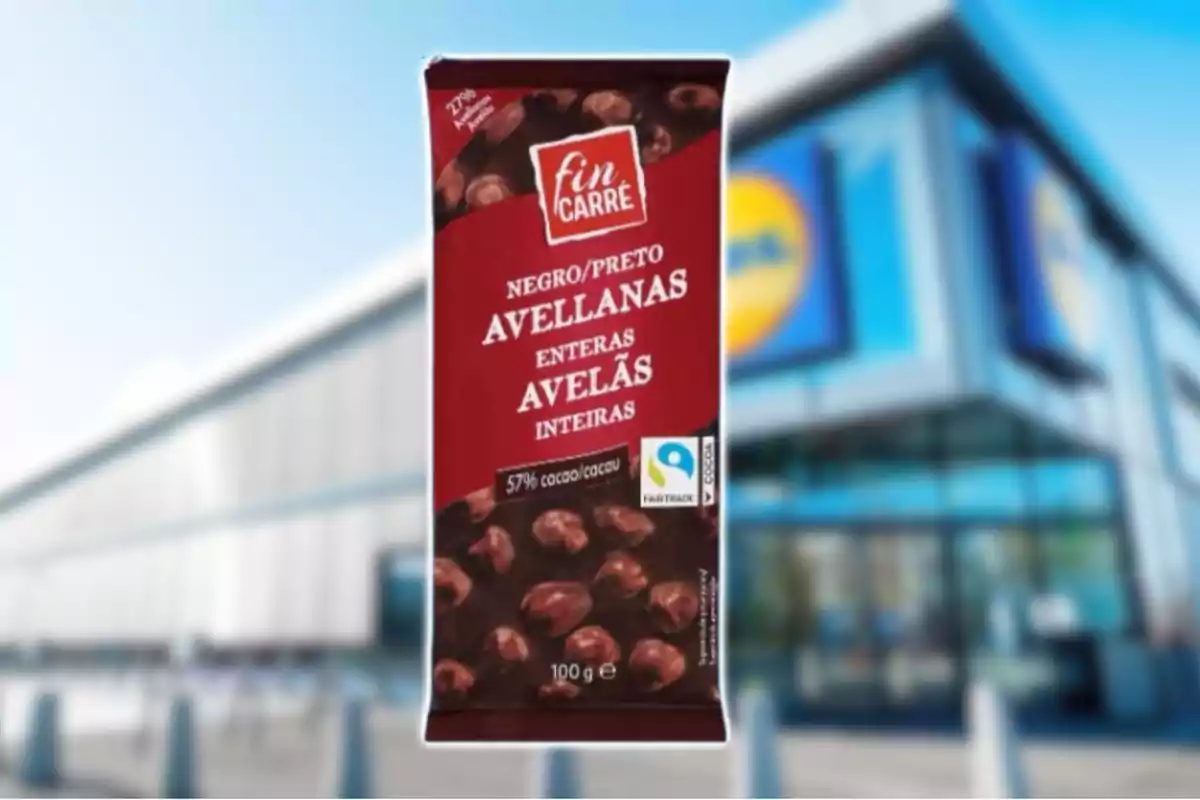 Tableta de chocolate negro con avellanas enteras de la marca Fin Carré frente a una tienda Lidl desenfocada Tableta de chocolate negro con avellanas enteras de la marca Fin Carré frente a una tienda Lidl desenfocada