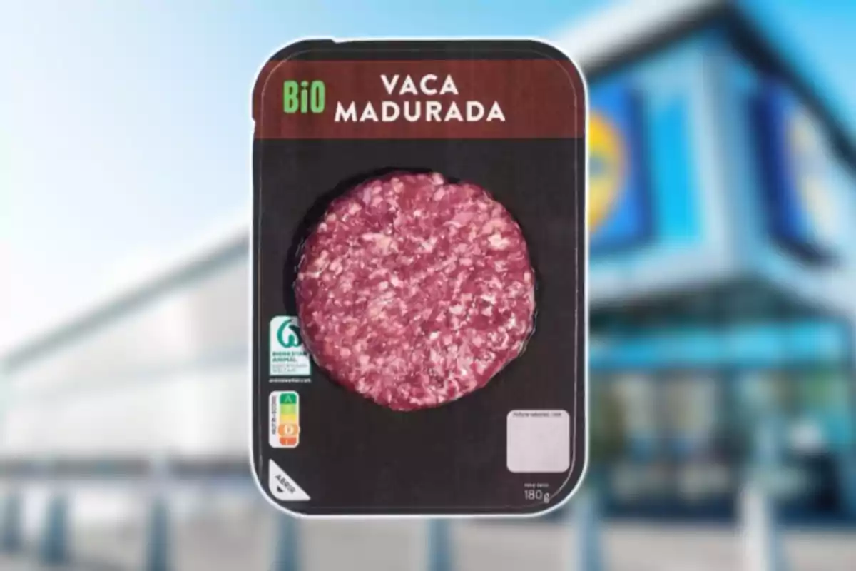 Hamburguesa de vedella madurada en un envàs negre amb etiqueta BIO davant d’un supermercat desenfocat Hamburguesa de vedella madurada en un envàs negre amb etiqueta BIO davant d’un supermercat desenfocat