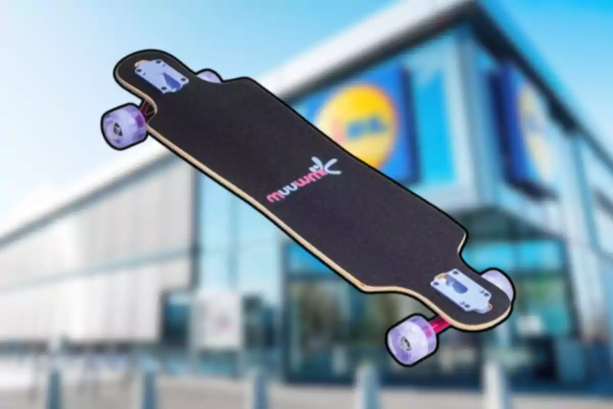 Patineta tipo longboard negra con ruedas transparentes frente a una tienda con fachada moderna desenfocada