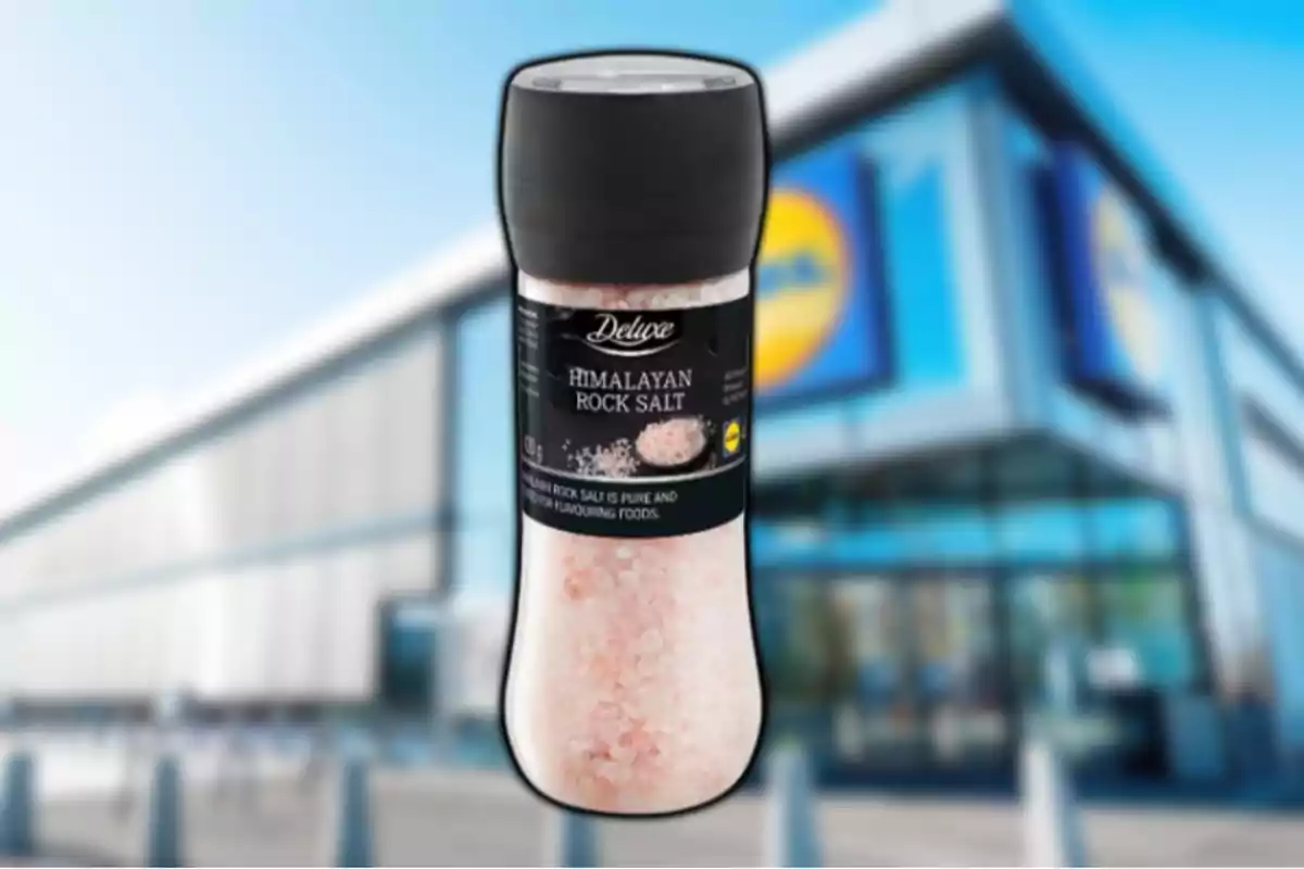 Un frasco de sal rosa del Himalaya de la marca Deluxe frente a una tienda Lidl desenfocada