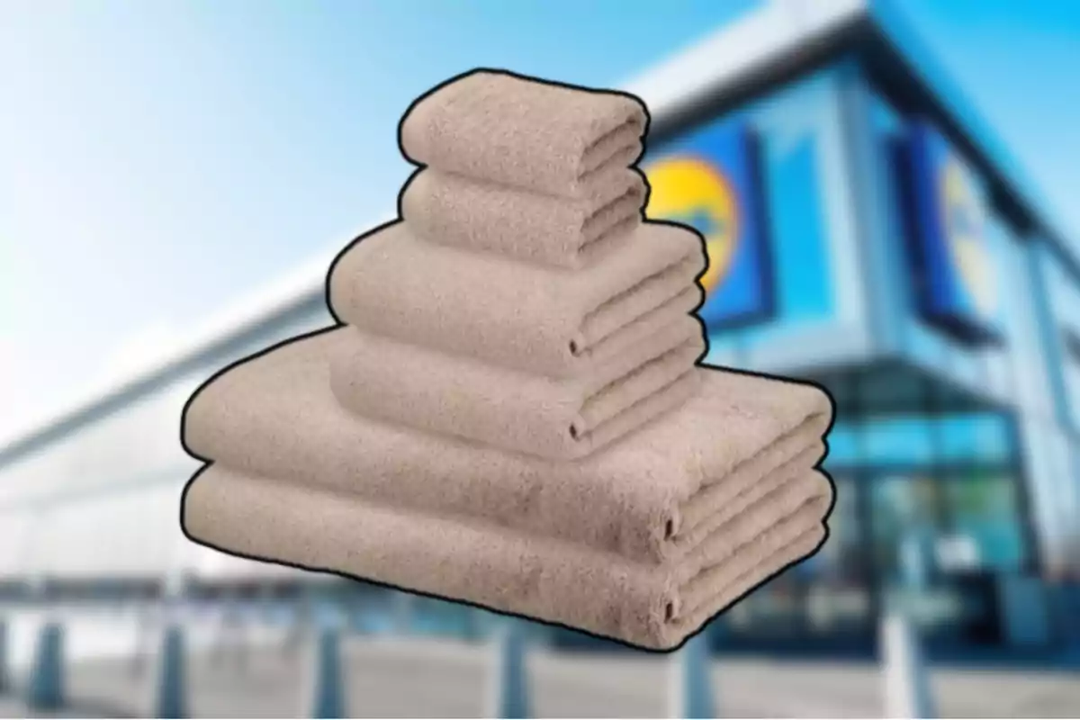 Un joc de tovalloles beix apilades davant d’una botiga amb façana moderna desenfocada Un joc de tovalloles beix apilades davant d’una botiga amb façana moderna desenfocada