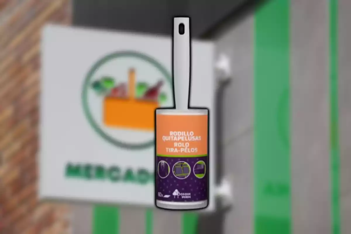 Rulló llevapelusses amb mànec blanc i etiqueta taronja i lila davant d’un rètol borros de supermercat Rulló llevapelusses amb mànec blanc i etiqueta taronja i lila davant d’un rètol borros de supermercat