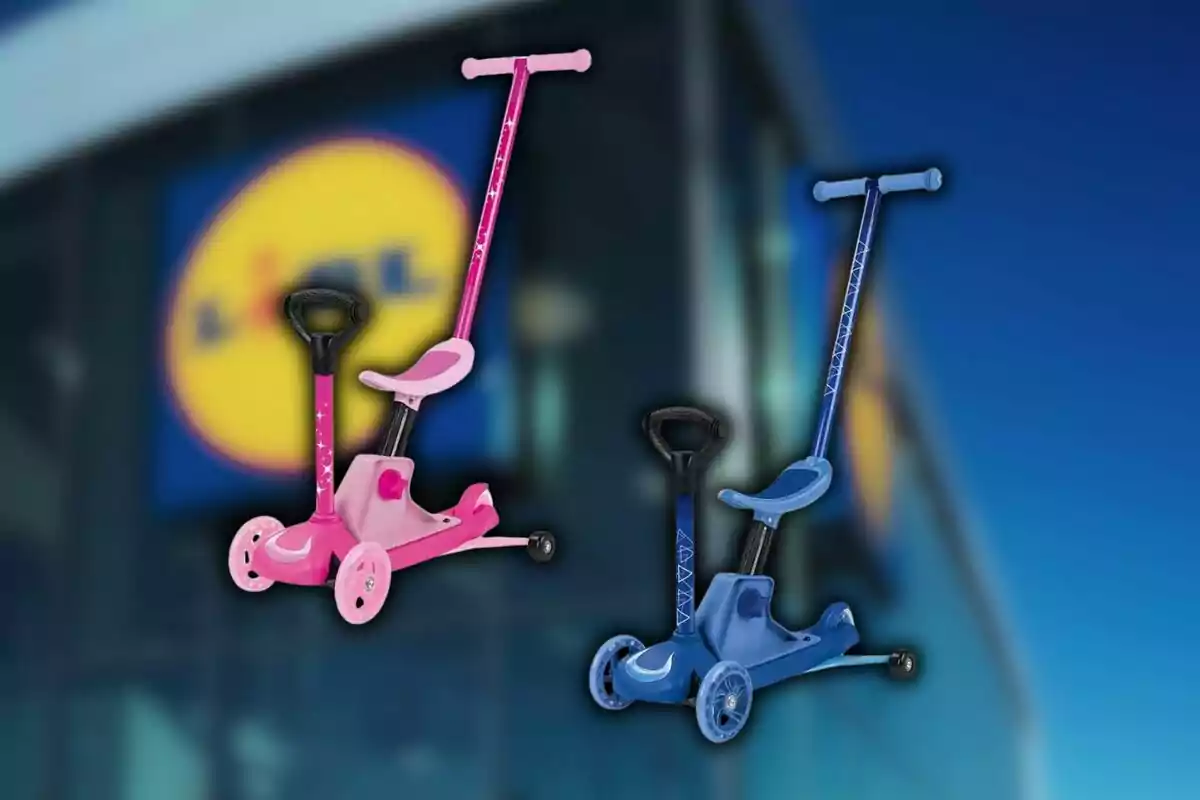 Dos patinetes infantiles, uno rosa y otro azul, están frente a un fondo desenfocado de una tienda con el logo de Lidl. Dos patinetes infantiles, uno rosa y otro azul, están frente a un fondo desenfocado de una tienda con el logo de Lidl.