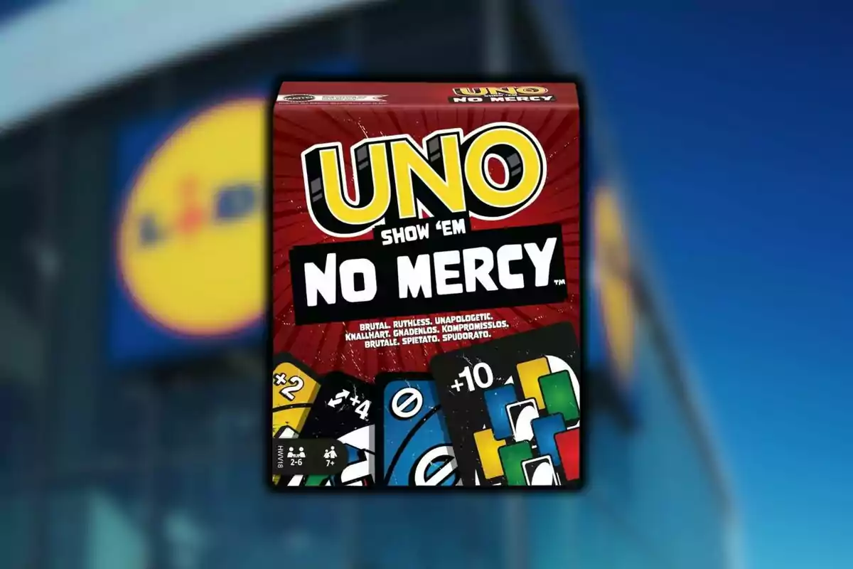 Caixa del joc UNO No Mercy davant d’un fons borros amb el logotip d’una botiga Lidl.