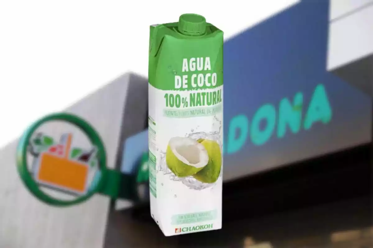 Envàs d'aigua de coco 100% natural davant d'una botiga. Envàs d'aigua de coco 100% natural davant d'una botiga.