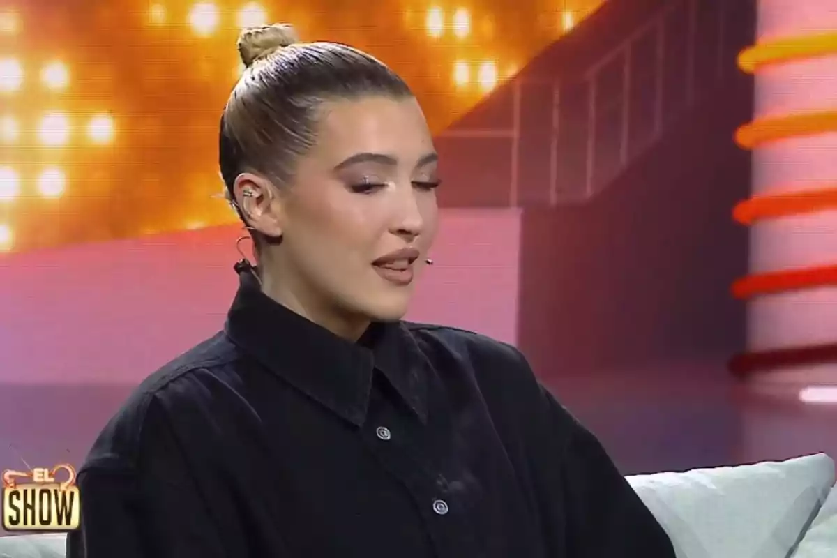 Alba Díaz, amb els cabells recollits i un micròfon a l'orella, està asseguda al plató de 'El show de Bertín'. Alba Díaz, amb els cabells recollits i un micròfon a l'orella, està asseguda al plató de 'El show de Bertín'.