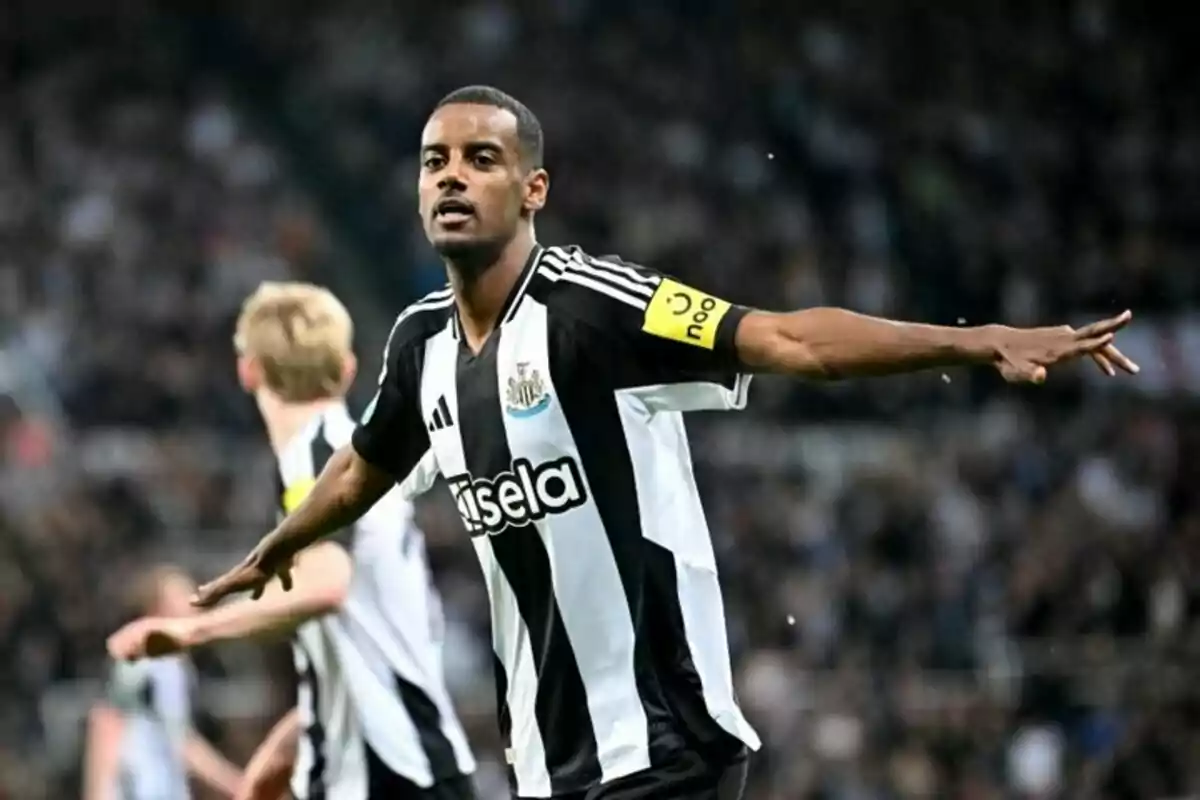 Soccer player celebrating a goal with his arms outstretched in a stadium. Soccer player celebrating a goal with his arms outstretched in a stadium.