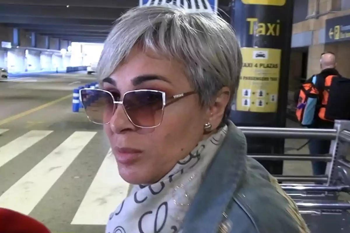 Ana María Aldón amb ulleres de sol i cabell curt canós està en una àrea de taxis. Ana María Aldón amb ulleres de sol i cabell curt canós està en una àrea de taxis.