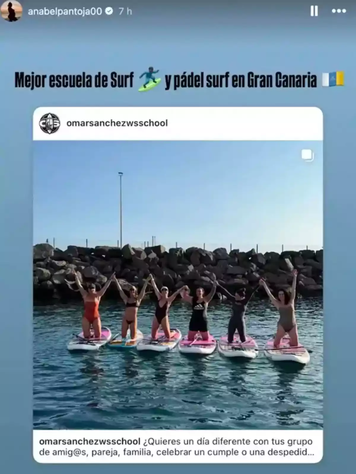 Grup de sis persones dretes sobre taules de paddle surf al mar, aixecant els braços i somrient, amb un fons de roques i cel serè. Grup de sis persones dretes sobre taules de paddle surf al mar, aixecant els braços i somrient, amb un fons de roques i cel serè.