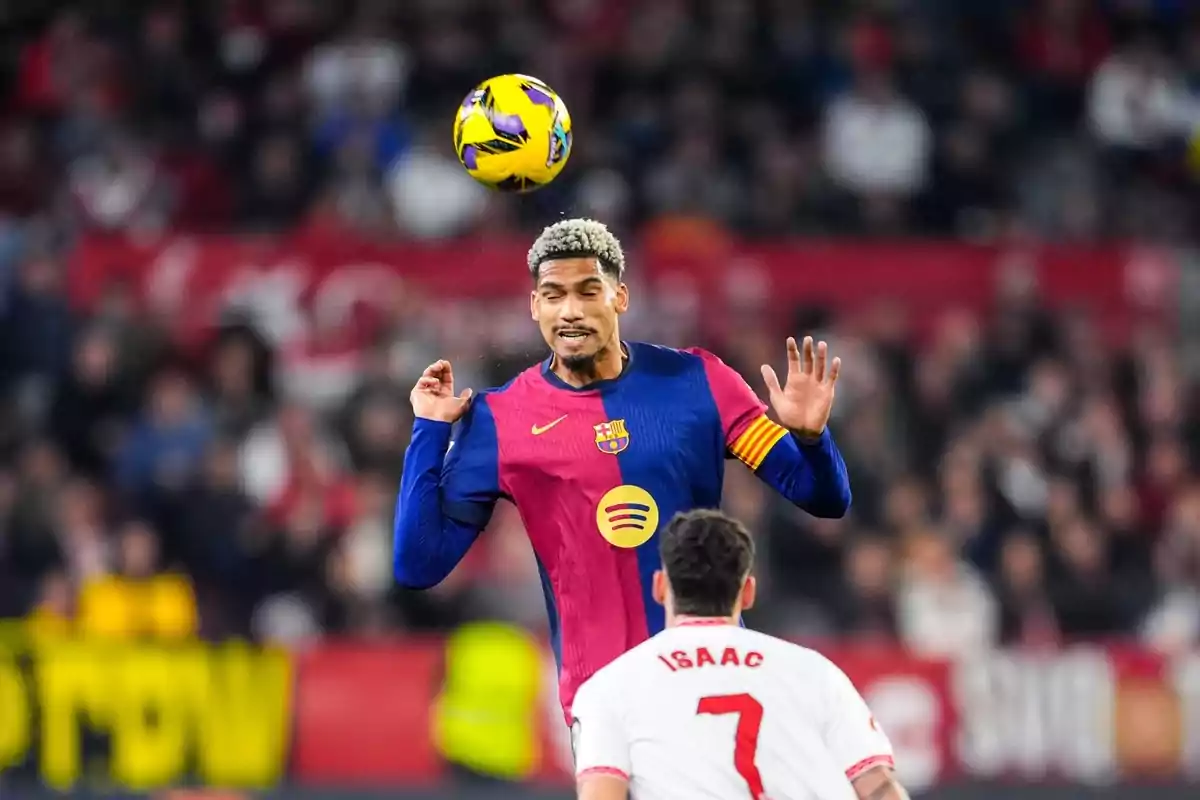 A player from Barcelona heads the ball while another player from the opposing team watches on the field.