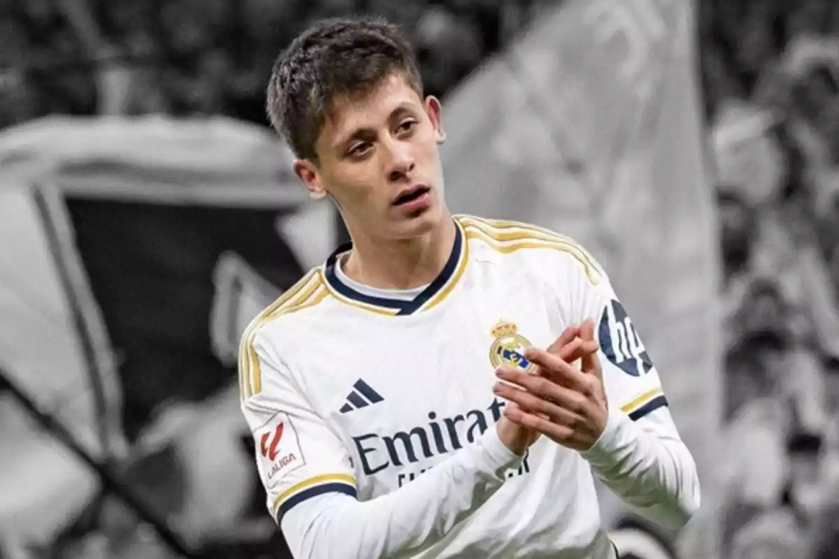 A football player in a Real Madrid uniform applauding on the field. A football player in a Real Madrid uniform applauding on the field.