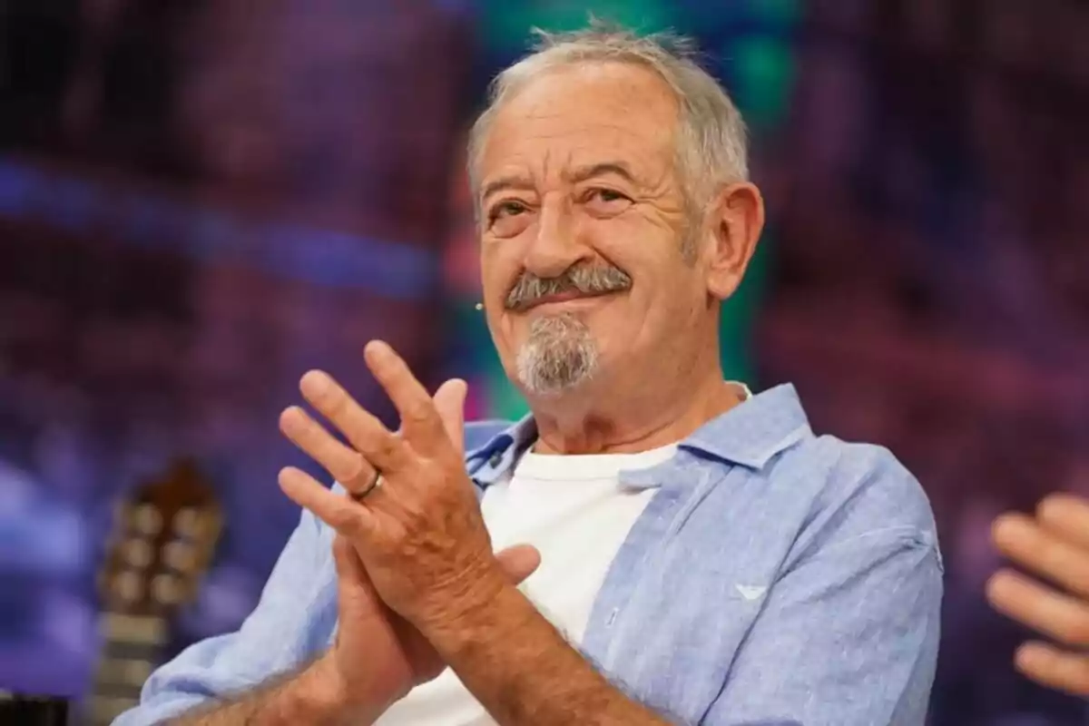 Karlos Arguiñano amb barba i bigoti somriu i aplaudeix mentre està assegut en un ambient colorit a 'El Hormiguero'. Karlos Arguiñano amb barba i bigoti somriu i aplaudeix mentre està assegut en un ambient colorit a 'El Hormiguero'.