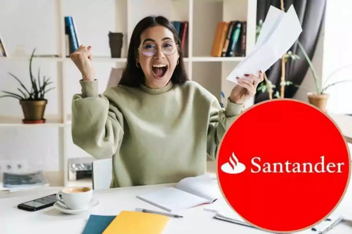 Una dona somrient amb ulleres i suèter verd celebra mentre sosté uns papers, amb el logotip de Santander en primer pla.