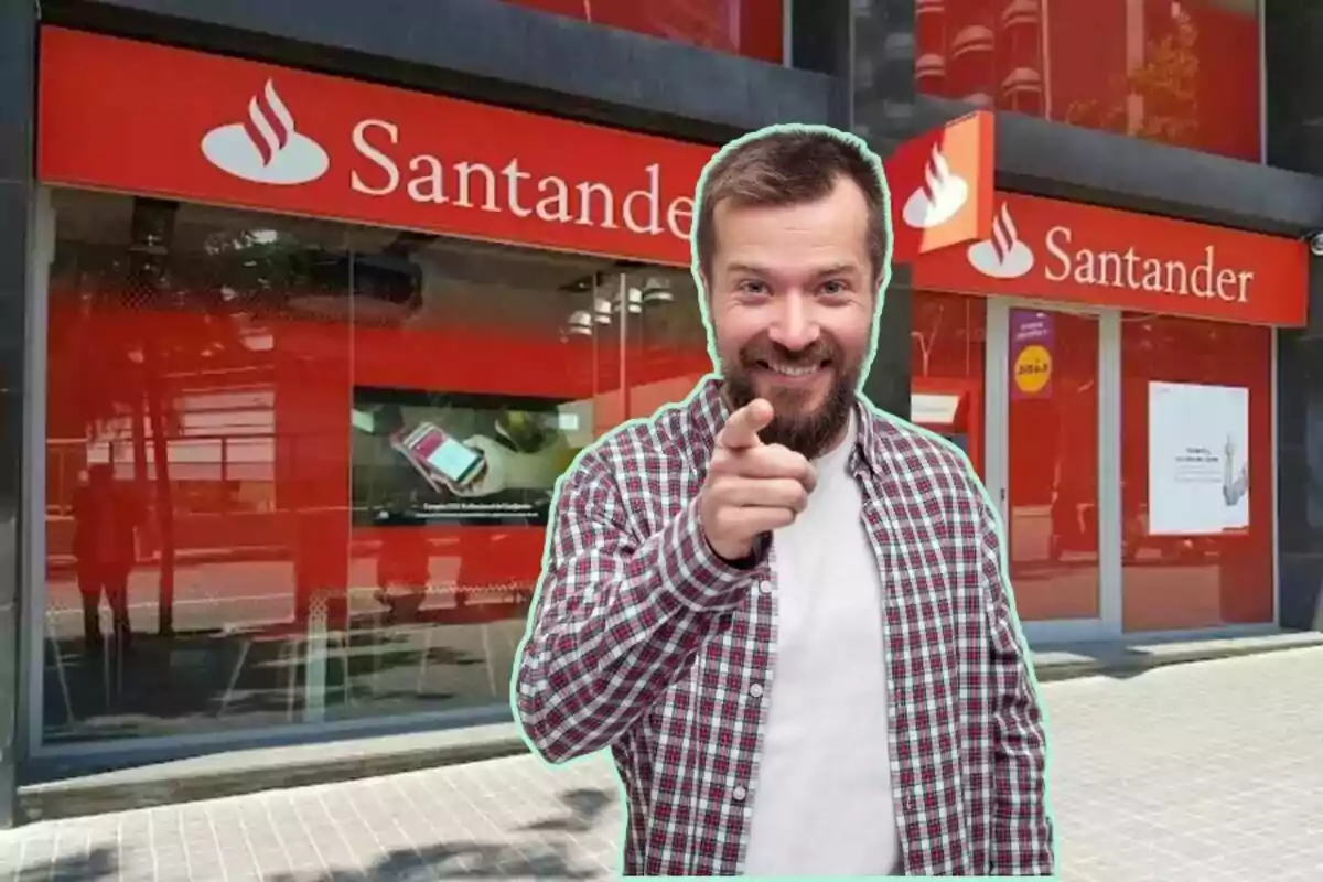 Un home somrient amb barba i camisa a quadres assenyalant endavant, amb una sucursal del banc Santander de fons.