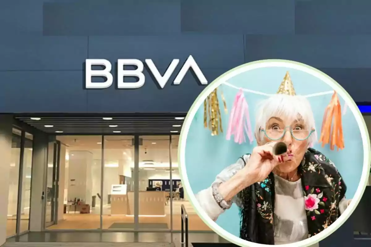 Façana d?una sucursal de BBVA amb una imatge circular d?una dona gran celebrant una festa amb un barret d?aniversari i un matasogres.