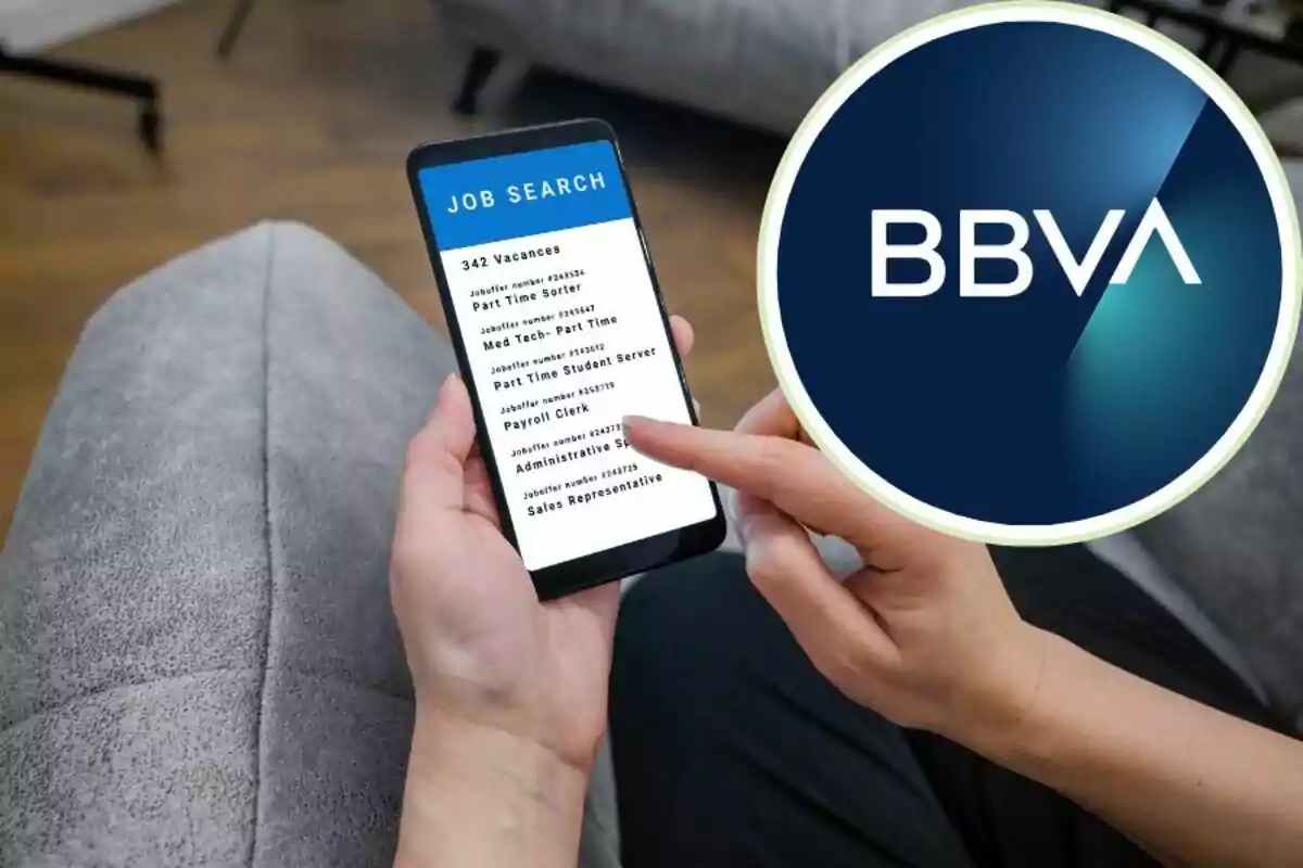 Persona usant un telèfon mòbil per buscar llocs de treball amb el logotip de BBVA a la cantonada. Persona usant un telèfon mòbil per buscar llocs de treball amb el logotip de BBVA a la cantonada.