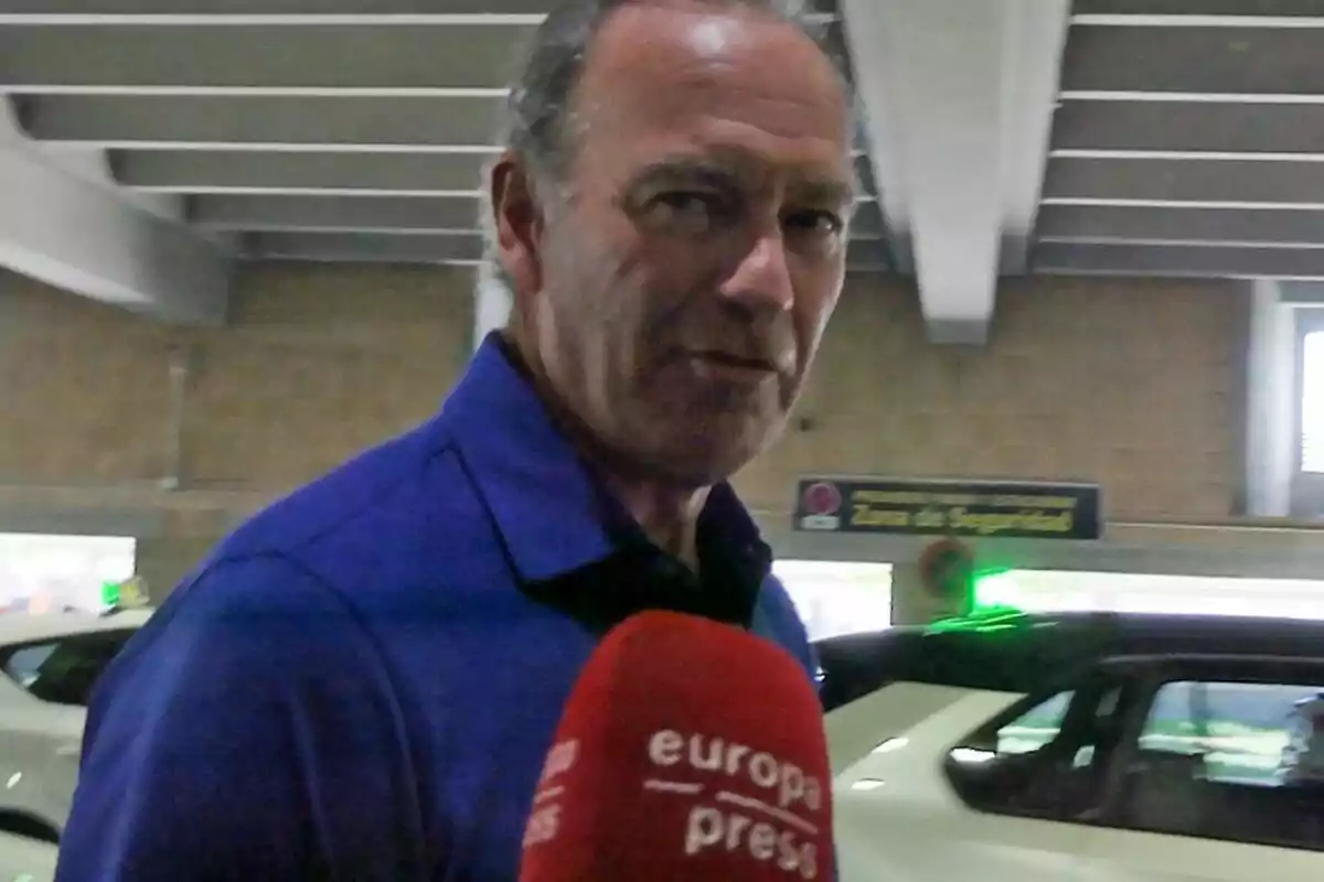 Bertín Osborne amb camisa blava sent entrevistat per Europa Press en un estacionament.