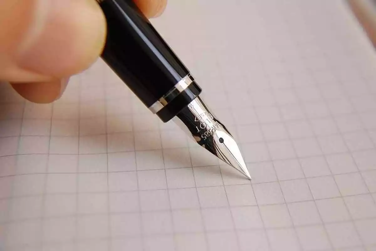 Imatge d'una persona escrivint amb un bolígraf