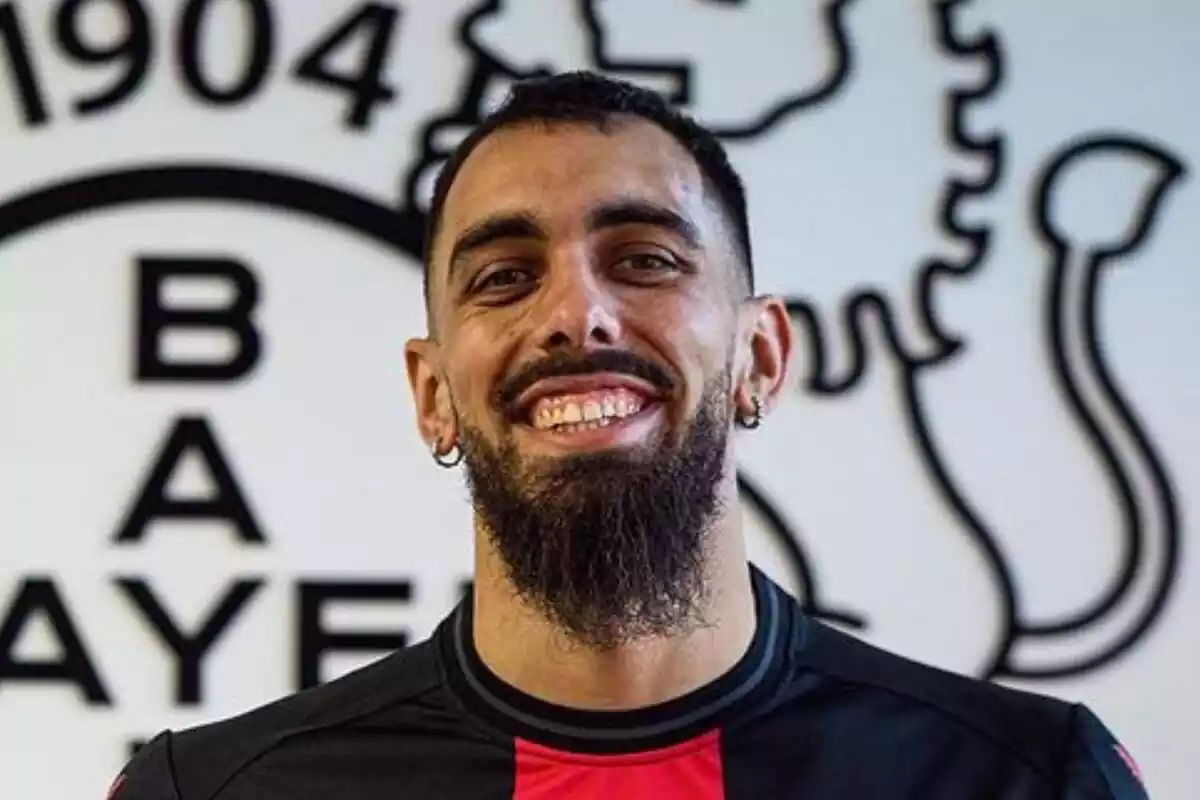 Borja Iglesias sonriendo con una camiseta negra y roja