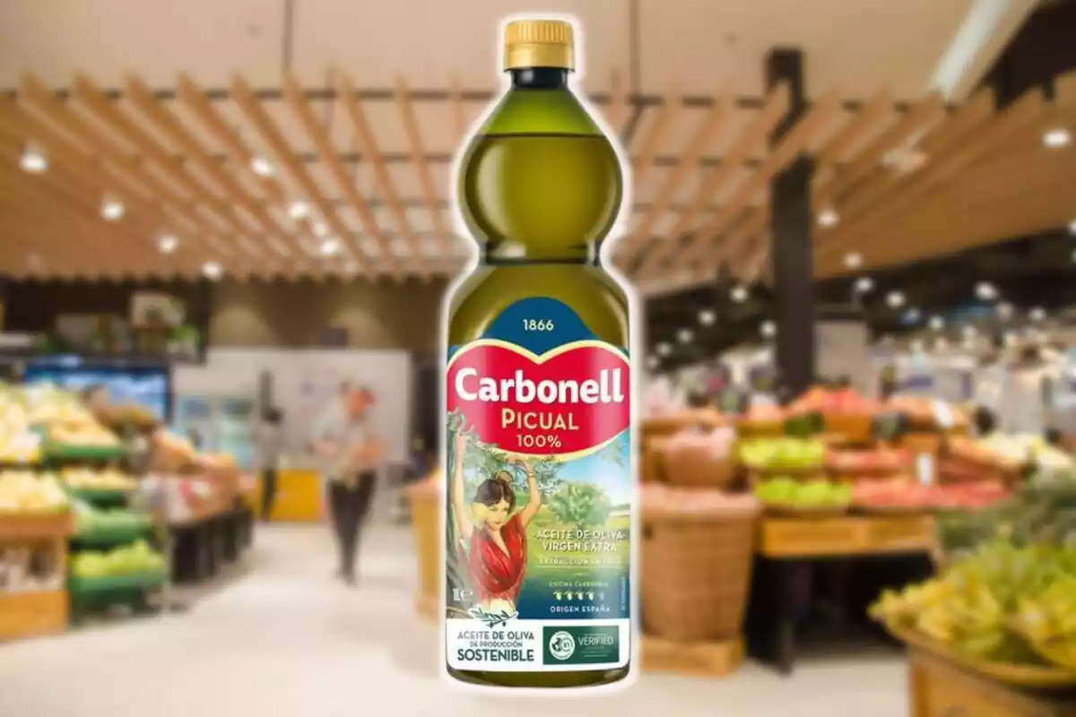 Ampolla d´oli d´oliva verge extra picual de la marca Carbonell amb un fons difuminat d´un supermercat