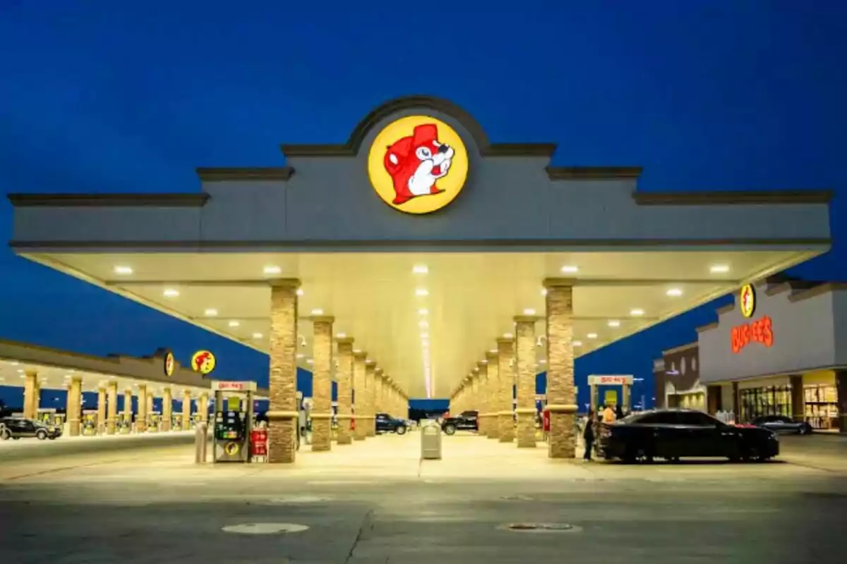 Una estació de servei il·luminada a la nit amb un logotip de castor al sostre i diversos sortidors de gasolina. Una estació de servei il·luminada a la nit amb un logotip de castor al sostre i diversos sortidors de gasolina.