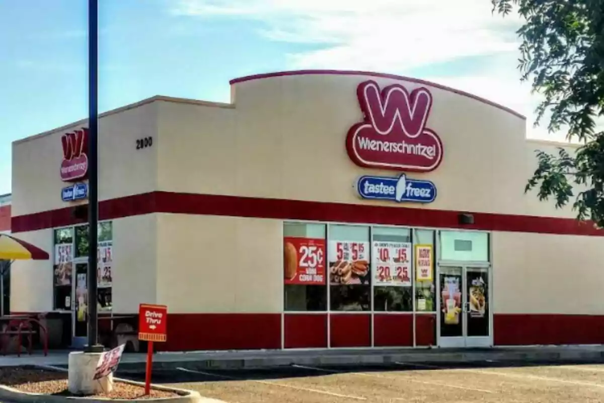 Restaurante de comida rápida Wienerschnitzel con letrero de Tastee Freez y anuncios de promociones en las ventanas Restaurante de comida rápida Wienerschnitzel con letrero de Tastee Freez y anuncios de promociones en las ventanas