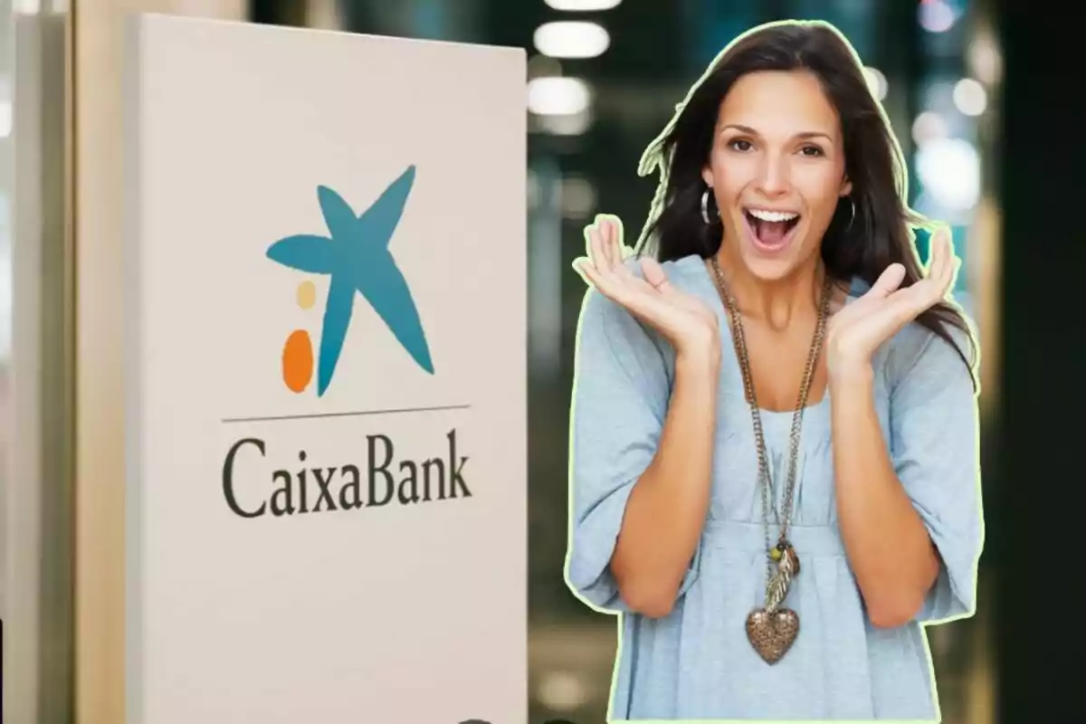 Una dona somrient amb les mans aixecades al costat d'un cartell de CaixaBank.