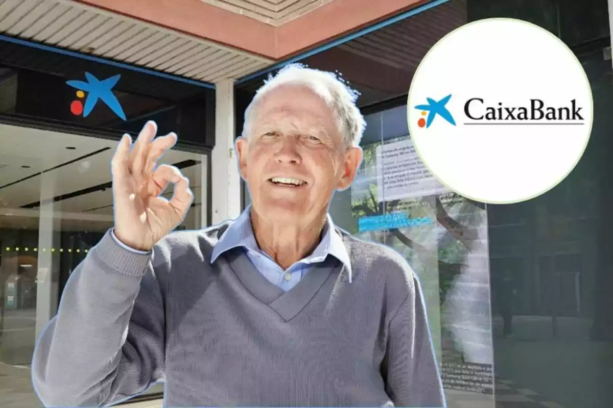 Un home gran somrient fa un gest d'"OK" amb la mà davant d'una sucursal de CaixaBank.