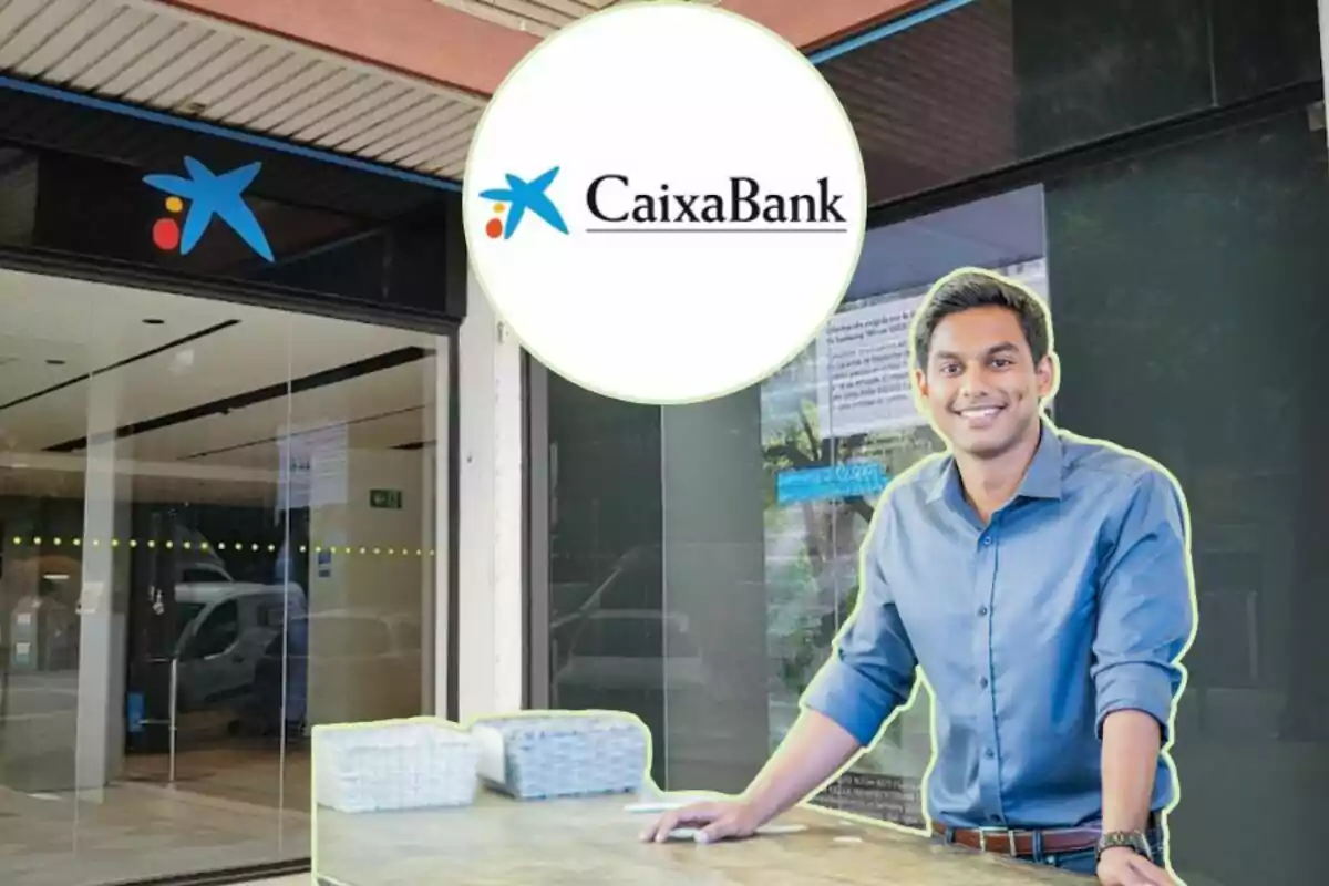 Un home somrient amb camisa blava està dret davant una sucursal de CaixaBank, amb el logotip del banc visible a la part superior de la imatge.