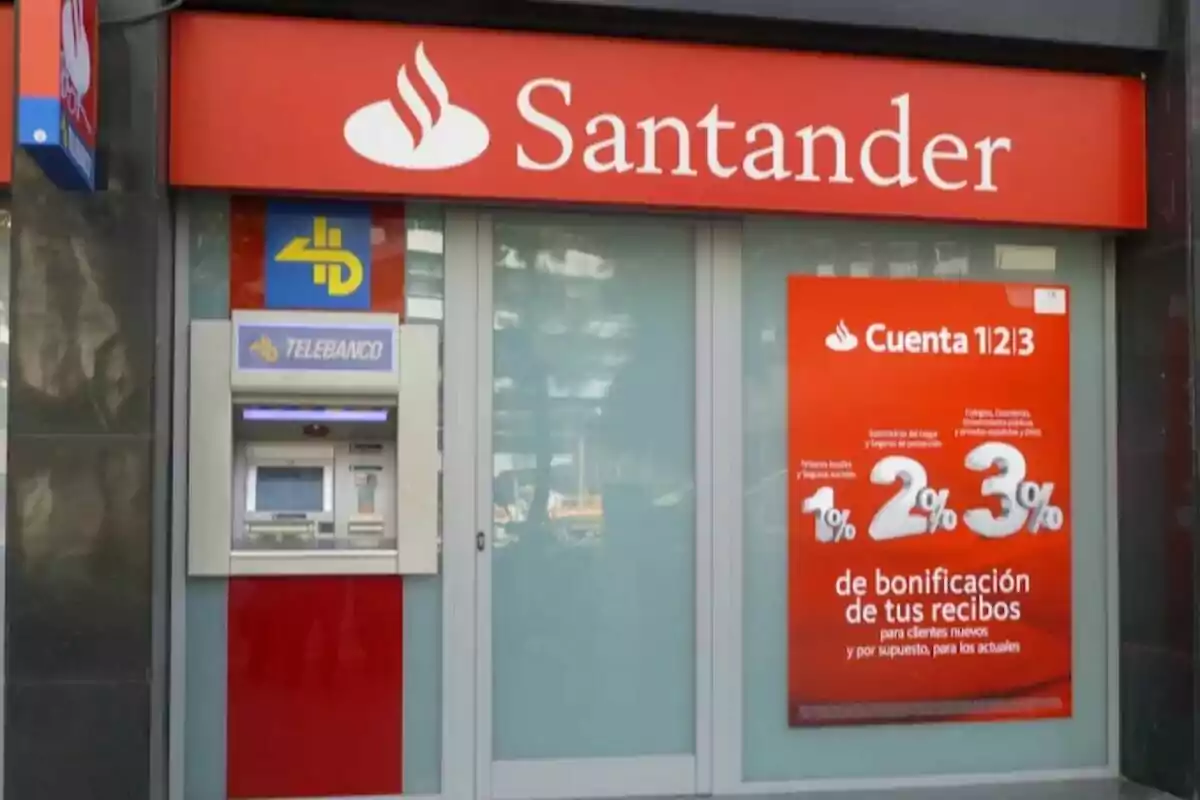 Façana d'una sucursal del banc Santander amb un caixer automàtic i un cartell promocional del compte 1|2|3.